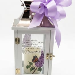 White memorial lantern with a purple ribbon bow and printed candle inside