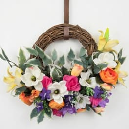 Floral wreath with colorful blooms on a grapevine ring