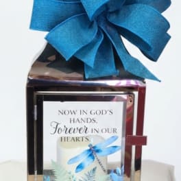 Decorative memorial lantern with a large blue bow and sympathy message