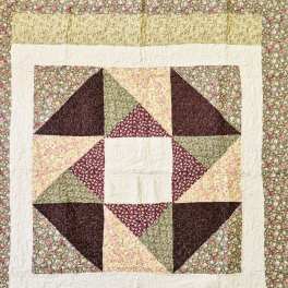 Patchwork quilt with floral prints and a star pattern in burgundy, green, and cream
