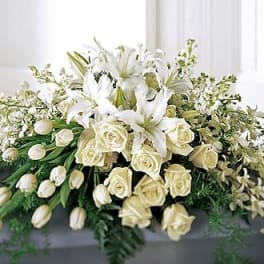 White lilies and roses arranged in a low floral display