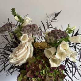 Cream roses and foxglove in a mixed floral arrangement