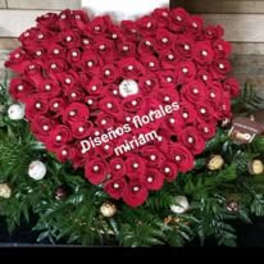 Heart-shaped arrangement of red roses with white accents