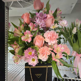 Pink mixed bouquet in a black Prada gift bag