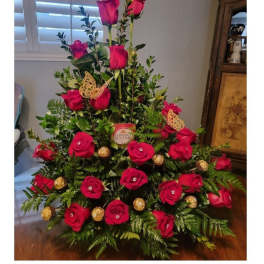 Tall arrangement of red roses with gold chocolates and butterfly picks