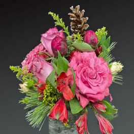 Pink roses and red alstroemeria in a rustic vase