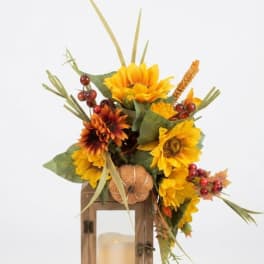 Sunflower arrangement in a wooden lantern with a candle inside