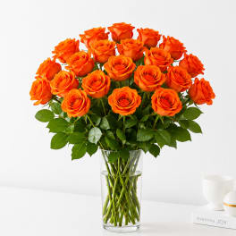 Orange roses arranged in a clear glass vase
