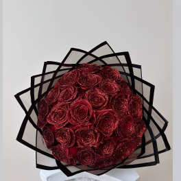 Bouquet of glittery red roses wrapped in black-edged paper