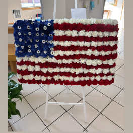 Floral American flag display on a white easel