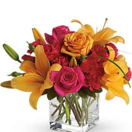 Bouquet of pink roses and yellow lilies in a clear glass vase