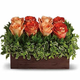 Rectangular arrangement of peach and red roses in a wooden box