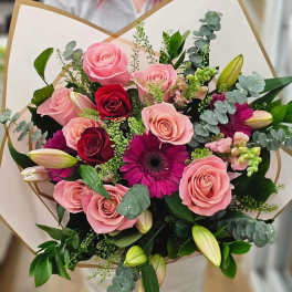 Bouquet of pink and red roses with magenta gerbera daisies