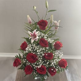 Red roses and white lilies arranged in a clear glass vase