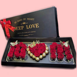 Gift box with red roses, Ferrero Rocher chocolates, and a red ribbon