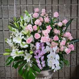 Large pink and white floral arrangement in a silver urn vase