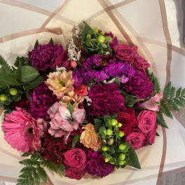 Mixed bouquet of pink and magenta flowers with peach accents