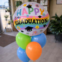 Graduation balloon bouquet with colorful latex balloons and a round "Happy Graduation" balloon
