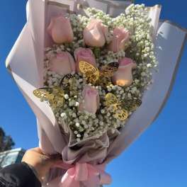 Bouquet of pale pink roses with white baby's breath and butterfly accents