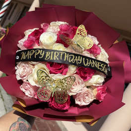 Pink and white rose bouquet with a birthday ribbon and butterfly decorations