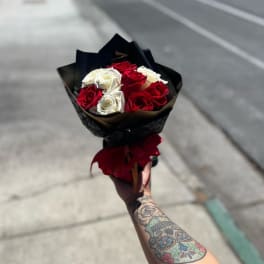 Bouquet of red and white roses wrapped in black paper