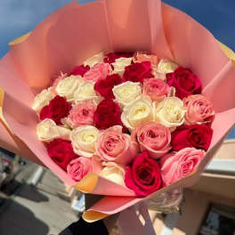 Bouquet of pink, red, and white roses wrapped in pink paper