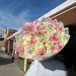 Large bouquet of pink and cream roses with a pink lily