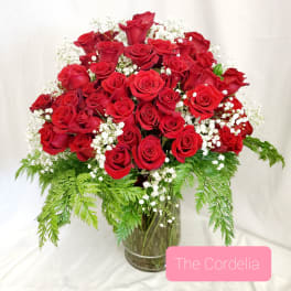 Red roses arranged in a glass vase with white baby's breath