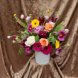 Mixed bouquet in a white vase with roses, gerbera daisies, and snapdragons