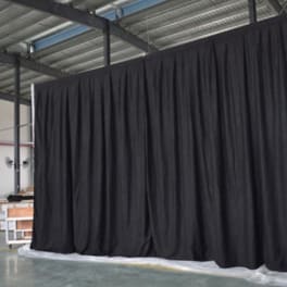 Large black curtain backdrop hanging in an industrial space