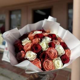 Bouquet of red, white, and peach roses wrapped in white paper
