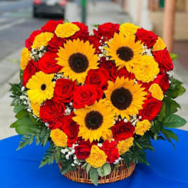 Heart-shaped basket arrangement of red roses and yellow sunflowers