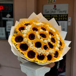 Bouquet of sunflowers and white roses wrapped in white paper