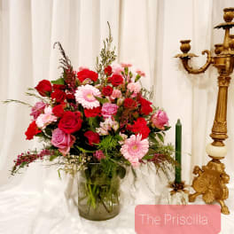 Mixed pink and red flower arrangement in a glass vase