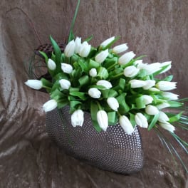 White tulips arranged in a textured dark vase