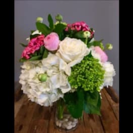 Bouquet of white, pink, and green flowers in a clear glass vase
