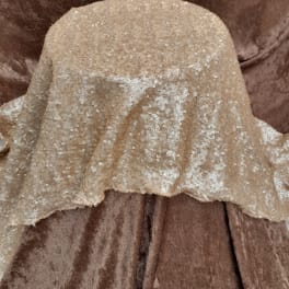 Beige sequined fabric draped over a brown upholstered chair