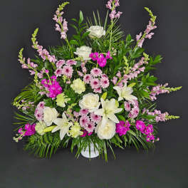 White lilies and roses with pink flowers in a white vase