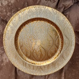 Decorative gold-toned charger plate with an embossed scroll pattern