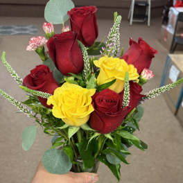 Bouquet of red and yellow roses with a decorative ribbon