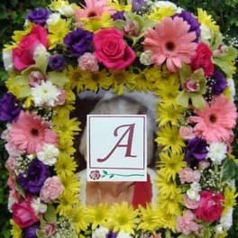 Colorful floral wreath with a monogram card in the center