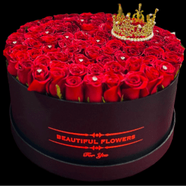 Round box of red roses topped with a gold crown