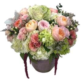 Pastel bouquet of roses, hydrangeas, and carnations in a gray vase