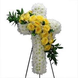 White and yellow floral standing cross on an easel
