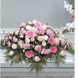 Pink and white floral casket spray with roses and daisy-like blooms