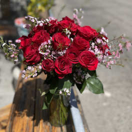 Bouquet of red roses with small pink filler flowers in a glass vase
