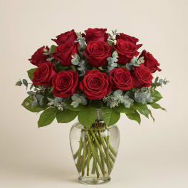 Red roses arranged in a clear glass vase