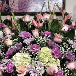 Basket arrangement of pink roses, lilies, hydrangeas, and purple mums
