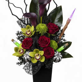 Tall arrangement of red roses and purple calla lilies in a black vase