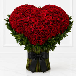 Heart-shaped bouquet of red roses with a black ribbon wrap